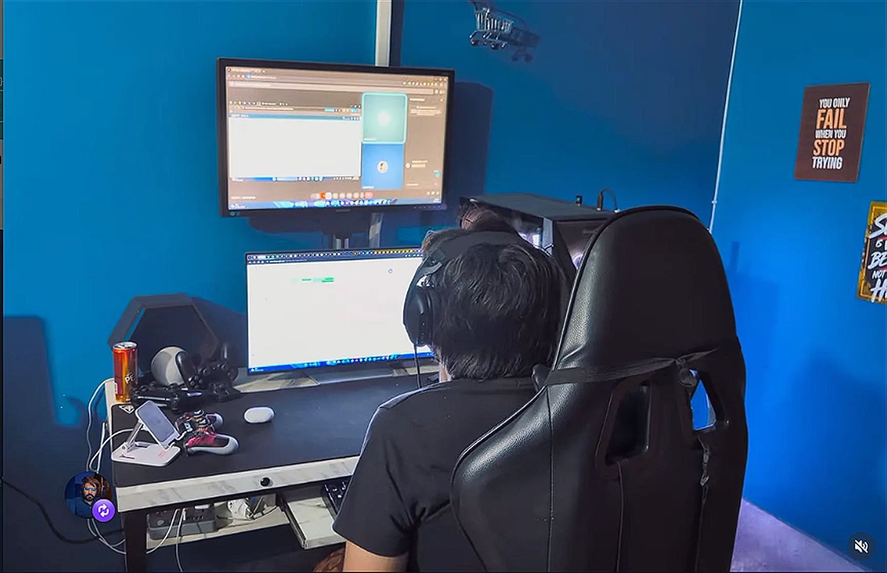 Umair working at his blue-wall desk setup with dual monitors